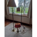 A brass standard lamp with shade together with a wrought iron standard lamp