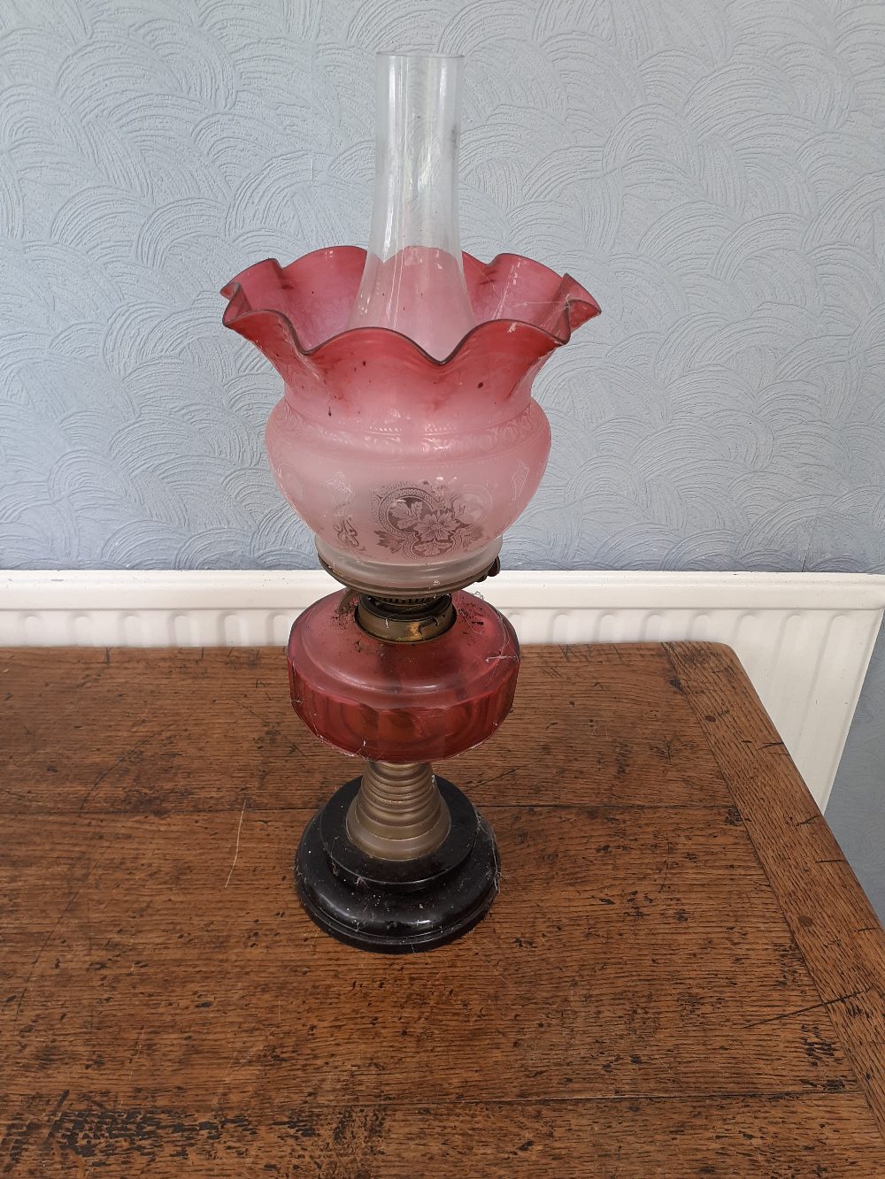 A Victorian glass Oil lamp with etched cranberry glass shade