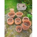 A composite Square planter and a collection of terracotta pots