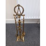 A Edwardian brass fire companion