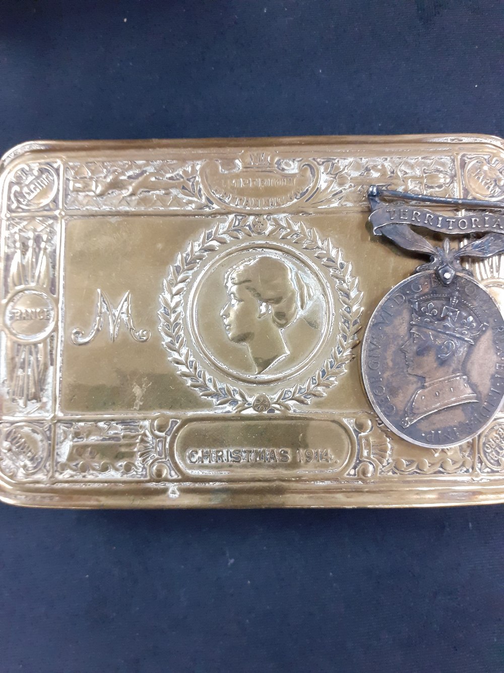 A WW1 brass chocolate tin 1914 together with a territorial medal.