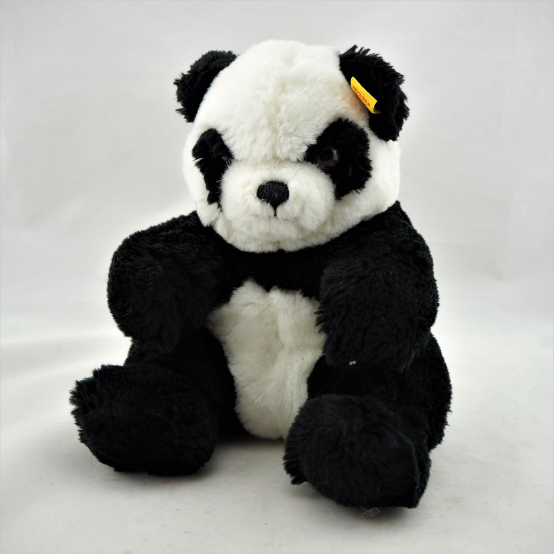 "Steiff" PandaPandabär der Marke "Steiff". Gelbe Fahne mit Knopf im Ohr. H.22cm.