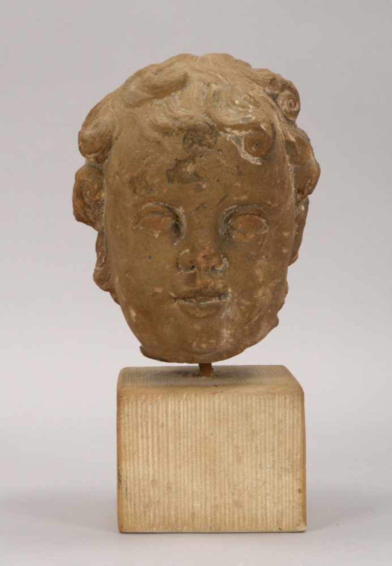 Antiker 'Putto-Kopf', Sandstein, auf kubischem Kalksandstein-Sockel; Gesamthöhe 31 cm