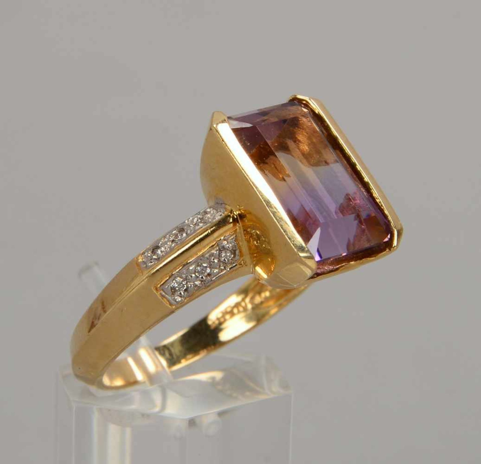 Ring, 585 GG, besetzt mit einzelnem Amethyst/Maße 14 x 9,8 mm, und 12x Begleitdiamanten/zusammen ca.