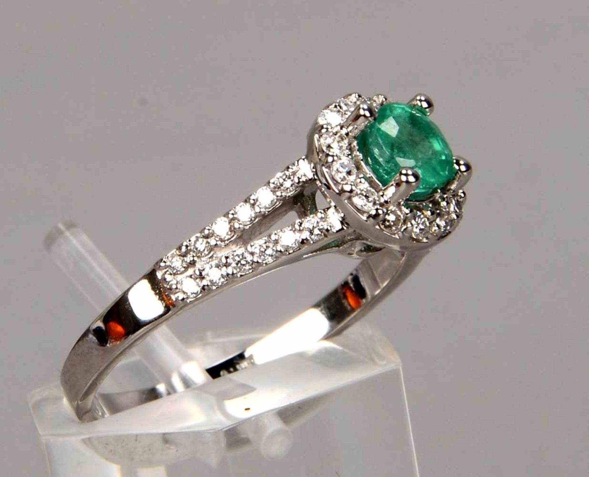 Ring, 750 WG, besetzt mit einzelnem Smaragd von ca. 0,63 ct, und mit mehrfachem Brillantbesatz/