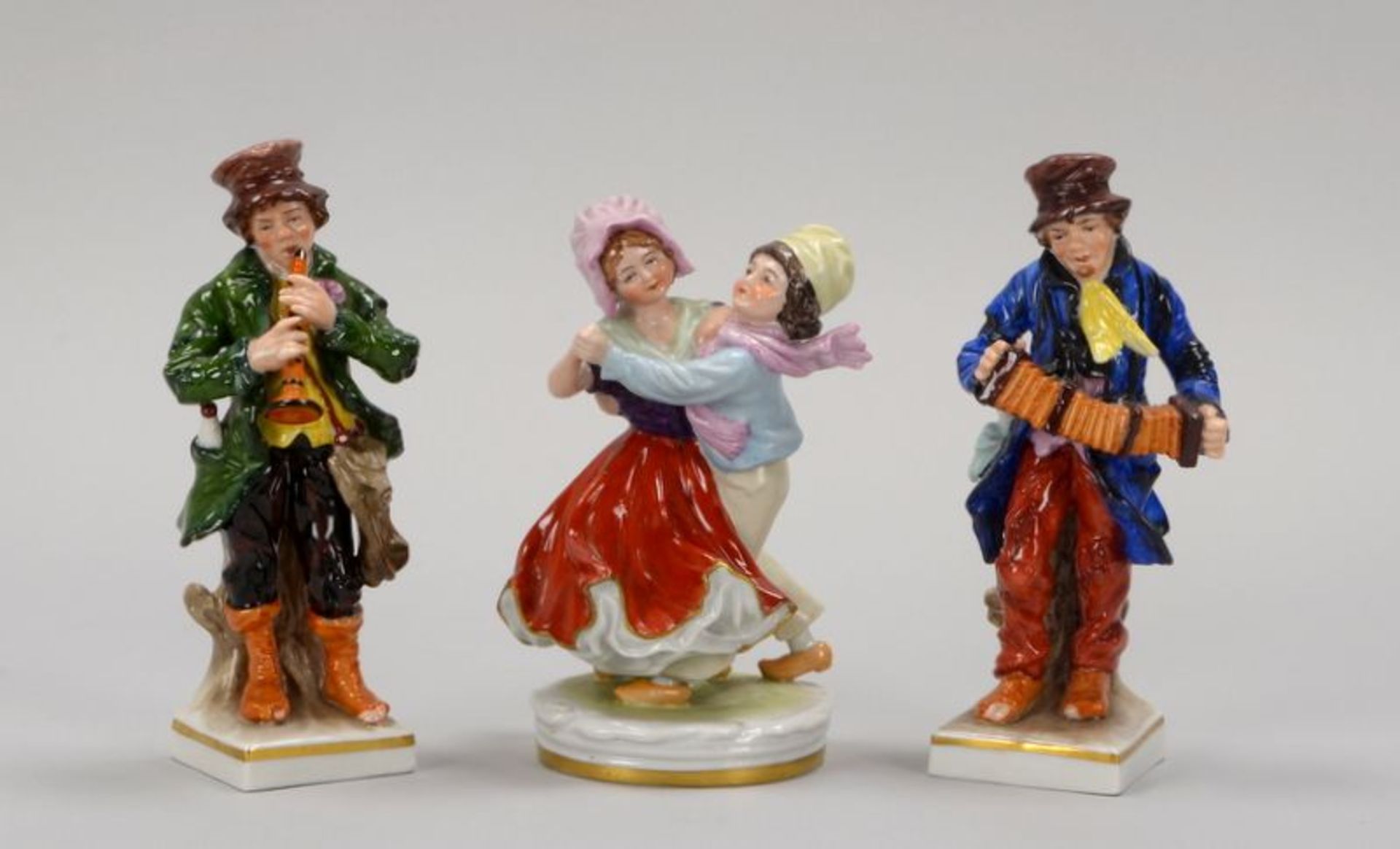 Kleines Porzellanfiguren-Konvolut, farbig staffiert, gemarkt, 3 Stück: 'Flötenspieler', und '