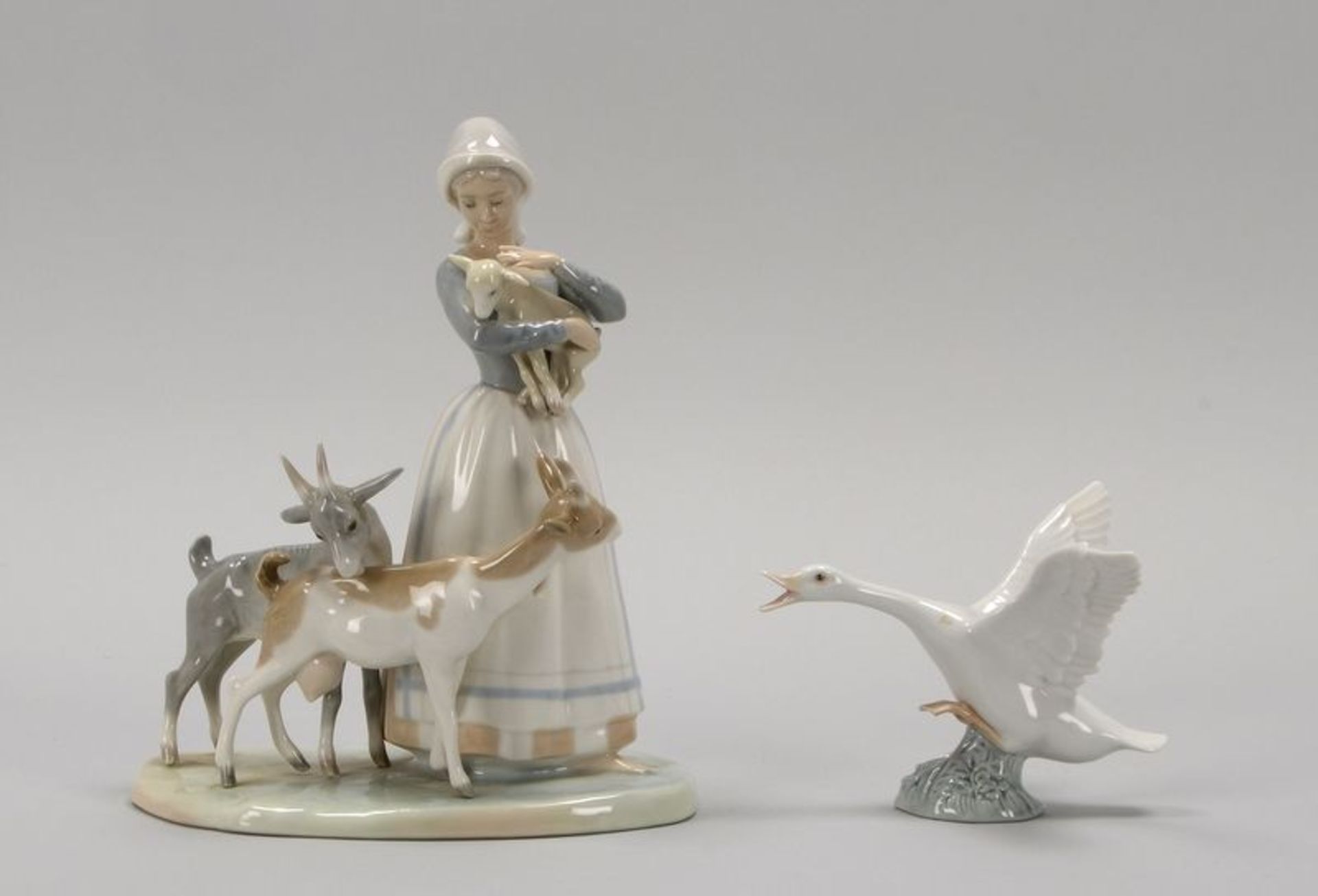 Lladro/Spanien, 2 Porzellanfiguren, pastellfarben staffiert, gemarkt: 1x 'Junge Frau mit Ziegen und