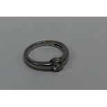 A diamond single stone gypsy set ring in rubover m