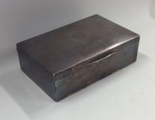 A rectangular engine turned silver cigarette box.