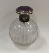 An enamel topped silver scent bottle with stopper.