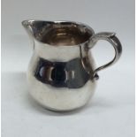 A heavy silver cream jug on flat base. London. By