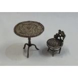 A silver filigree tripod table together with a cha