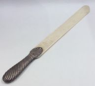 A massive silver paper knife with turned handle. A