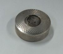 A small circular engine turned silver box with gil