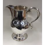 A massive George II silver beer jug on sweeping pedestal