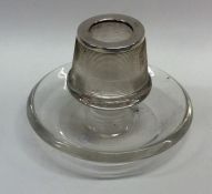 A silver match striker on stand of circular form.