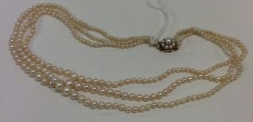 A triple string of pearl beads with gold clasp. Ap