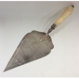 A large silver trowel with turned ivory handle. Bi