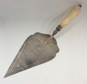 A large silver trowel with turned ivory handle. Bi