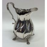 A heavy silver cream jug of swirl design. London.