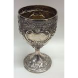 A silver embossed goblet decorated with flowers an