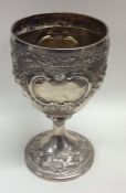 A silver embossed goblet decorated with flowers an