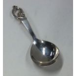 A stylish silver caddy spoon with scroll decoratio
