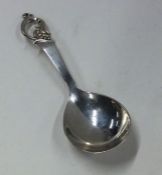 A stylish silver caddy spoon with scroll decoratio