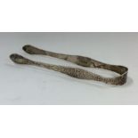A pair of bright cut silver sugar tongs with flora