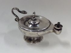 A small silver model of an Aladdin's lamp with sna