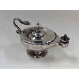 A small silver model of an Aladdin's lamp with sna