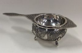 A Persian silver tea strainer on stand with floral