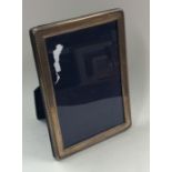 A modern rectangular silver picture frame with ree