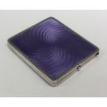 A silver and enamel cigarette case with scroll dec