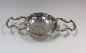 A Georgian silver lemon strainer with double cast