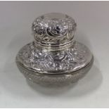 A silver embossed top inkwell with cut glass base.