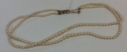 A good double string of pearl beads with 9 carat c