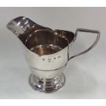 An Edwardian silver cream jug on spreading support