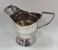 An Edwardian silver cream jug on spreading support