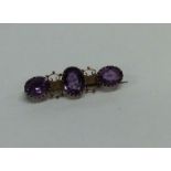 An amethyst three stone brooch set in 9 carat. App