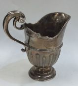 A heavy Victorian silver cream jug on spreading su