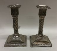 A pair of Edwardian silver candlesticks on stepped