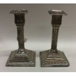 A pair of Edwardian silver candlesticks on stepped