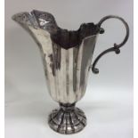 A tall Italian silver ewer with fluted body to spr