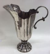 A tall Italian silver ewer with fluted body to spr