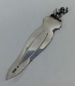 A small novelty silver bookmark decorated with a f