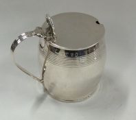 A silver barrel shaped mustard pot with hinged top