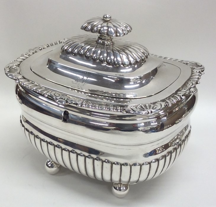 A Georgian silver half fluted tea caddy on ball fe
