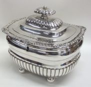 A Georgian silver half fluted tea caddy on ball fe