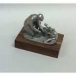 A novelty cast silver model of a poacher on mahoga